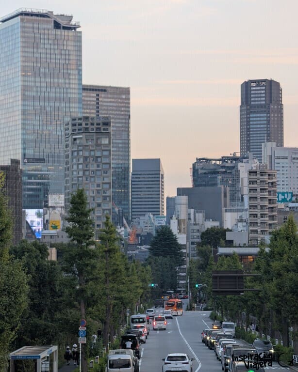 Rascacielos de Shibuya al atardecer con el tráfico y árboles en primer plano